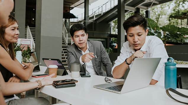 Workers sit together at a talking in an office